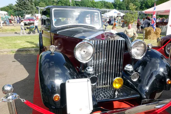 stock image Lviv, Ukraine - June 6, 2017 A beautifully restored vintage car Rolls-Royce Phantom II captivates attendees at an outdoor festival, surrounded by people enjoying the sunny weather and festivities