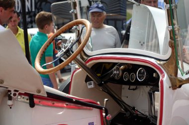 Lviv, Ukrayna - 2 Haziran 2018 Bir grup seyirci klasik bir klasik Buick 6-21 Speedster 1921 yazlık bir araba fuarı sırasında direksiyon simidini ön plana çıkaran iç mekanına hayran.