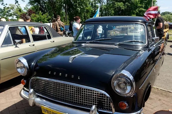 stock image Lviv, Ukraine - June 1, 2023 A gathering of vintage car Ford Consul enthusiasts showcases classic automobiles at a lively outdoor festival, with a beautiful backdrop of trees