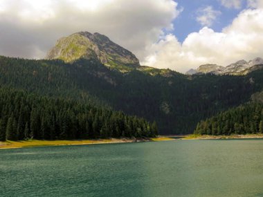 Uzun çam ormanları ve Karadağ 'ın gerçek mücevheri Durmitor Ulusal Parkı' ndaki görkemli Bobotov Dağı ile çevrili Kara Göl 'ün çarpıcı manzaralarını keşfedin..