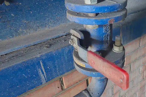 Lviv, Ukrayna - 29 Nisan 2025 Kazan sistemindeki yoğunlaştırıcı buharı düzenlemek için boru hattına mavi top valfi takıldı. Kapakçık, işlevsel verimlilik ve güvenlik açısından çok önemli..