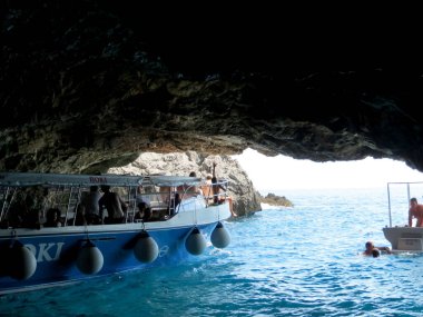 Herceg Novi Montenegro - 20 Temmuz 2014 Montenegros Blue Grotto 'da güneşli bir günün tadını çıkarıyor. Teknelerdeki turistler kristal berrak suları keşfederken, diğerleri çarpıcı mavi renklerde yüzüyor..