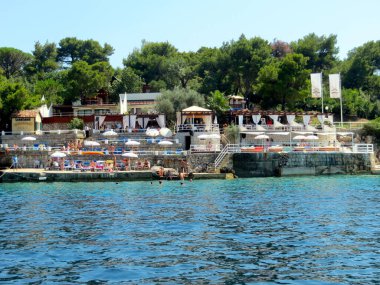 Zanjiç Karadağ - 20 Temmuz 2014 'te Pirat Kupaliste Plajı' nda berrak sularla güneşli bir günün tadını çıkarıyorlar. Ribarsko Selo restoranı Zanjiç 'te ambiyans ve Akdeniz mutfağı sunuyor.