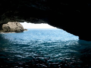 Parlak güneş ışığı Karadağ 'daki çarpıcı Blue Grotto' yu aydınlatıyor. Kristal berrak sular mavinin tonlarını yansıtırken dalgalar yavaşça kayalık girişe çarpıyor..