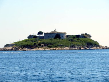Montenegros Adriyatik Denizi 'ndeki Lastavitsa Adası' nda güneşli bir günde turkuaz sular ve yemyeşil bitki örtüsüyle çevrili tarihi Fort Mamula 'yı keşfedin..