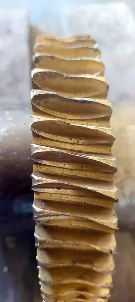 Bronz bir solucan dişlisi yakın plan, eşsiz çıkıntılı yapısını ve metalik dokusunu vurguluyor. Bu parça çeşitli makinelerdeki mekanik fonksiyonlar için çok önemlidir..