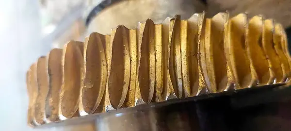 Bu yakın plan, bronz bir solucan dişlisinin karmaşık dizaynını yakalar, bir atölye ortamında çıkıntılı yapısını ve metalik parıltısını vurgular..