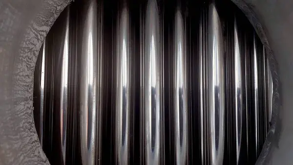 Yakın plan görüntüsü çelik ısı borularının cilalanmış iç kısımlarını ortaya çıkararak, termal değişim süreçlerinde kullanılan endüstriyel uygulamaların üretim kalitesini vurguluyor..