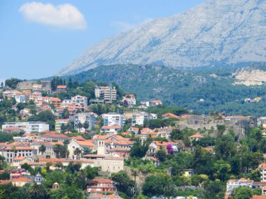 Herceg Novi, Boka Kotorska dağlarının güzel zeminine ve canlı yeşilliklere karşı modern mimarinin ortasındaki antik kalelerle zengin tarihini sergiliyor..