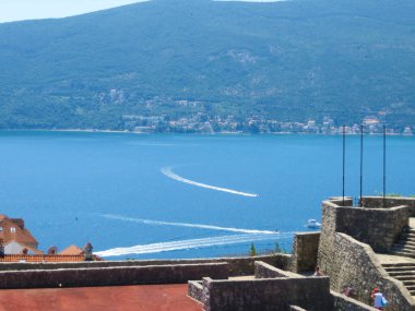 Ziyaretçiler Herceg Novi 'nin huzurlu güzelliğinin tadını çıkarıyorlar. Kotor Körfezi' nin ışıl ışıl sularına tepeden bakan mavi alanda süzülen teknelerle..