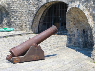 Ziyaretçiler, Karadağ 'ın Herceg Novi kentindeki güzel Kotor Körfezi boyunca uzanan tarihi bir yer olan Kanli Kula Kalesi' ndeki antik mimari ve antika bir topa hayranlık duyuyorlar..
