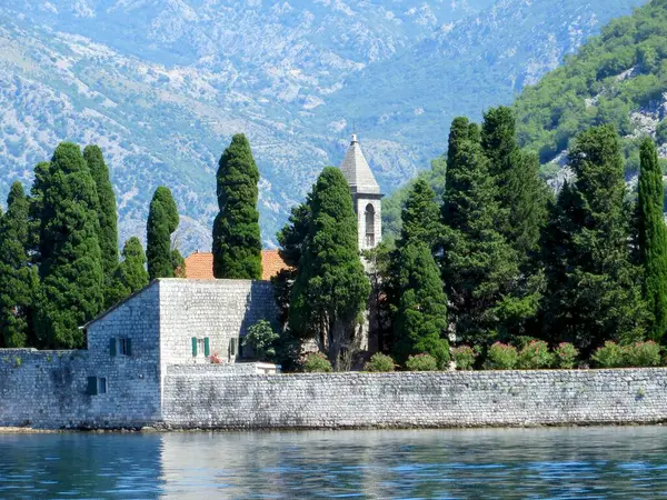 Aziz George Adası, Karadağ 'daki Kotor Körfezi' nin çarpıcı zeminine karşı kurulmuş uzun ağaçlar ve tarihi taş duvarlarla çevrili büyüleyici bir kilise sergiledi..