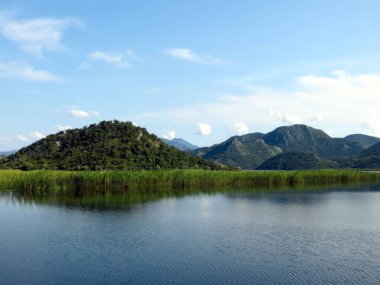 Skadar Gölü ziyaretçileri sakin sularını ve yemyeşil sularını kucaklamaya davet eder. Bu doğal mücevheri çevreleyen görkemli dağlar, Karadağ 'da barışçıl bir geri çekilme yaratıyor..