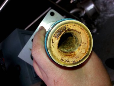 Bir teknisyen, vida pompası durumunu detaylı bir şekilde inceler, aşınma belirtilerini tespit eder ve bakım tesisinde pompa bileşeninin içinde yıpranır..