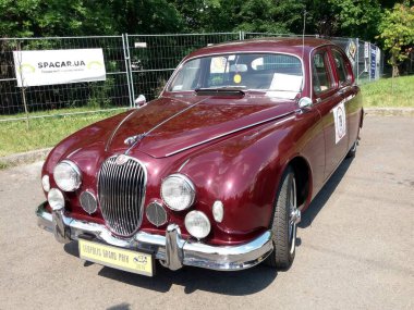 Lviv, Ukrayna - 6 Haziran 2018 Klasik bir Jaguar Mark MkII, parlak güneş ışığı altında çarpıcı bir kestane rengi ve parlak krom detaylarının yer aldığı bir araba sergisinde sergilenmektedir..