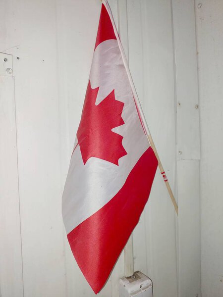 Red and white Canadian flag hangs on the wall, symbolizing national pride during a community gathering in Canada.