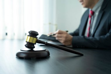 Tokmak avukatlarına odaklan ya da hâkim oturup üzerinde daha fazla fotokopi alanı olan antika tonda tabletli bir masada davayı düşün..