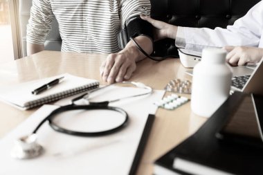 Doktor hastanın nabzını kontrol ediyor ve hastalığın nasıl tedavi edileceği konusunda tavsiye vermeye hazır..