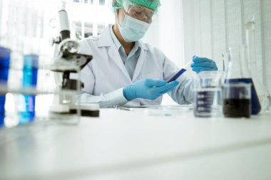 Bilim adamları bir kimya ve viroloji laboratuvarında tüp bebek kimyasına bakıyorlar..