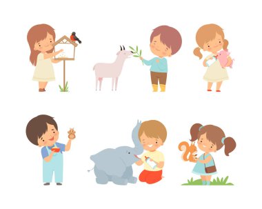 Yavru hayvanları besleyen bir grup sevimli çocuk. Küçük oğlanlar ve kızlar ispinoz, keçi, domuz, hamster, fil, sincap çizgi film çizimleri ile ilgileniyorlar.