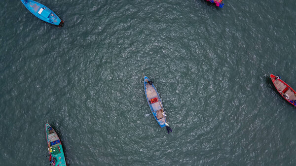 Вид с воздуха с беспилотника Красочные длинные хвостовые лодки в середине моря.