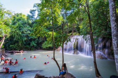 Kanchanaburi, Tayland-14 Ekim 2023: Turistler tatilde şelalelerde oynarken can yeleği giyerler, Tayland 'da güzel bir şelale.