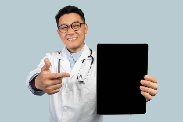 Beyaz Önlüklü Olgun Çinli Erkek Terapist Tableti Boş Ekranla Gösteren — Stok fotoğraf