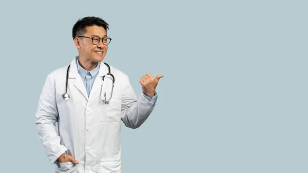 Ευτυχής Μεσήλικας Κορεάτης Γιατρός Λευκό Παλτό Γυαλιά Δείχνει Δάχτυλο Στο — Φωτογραφία Αρχείου