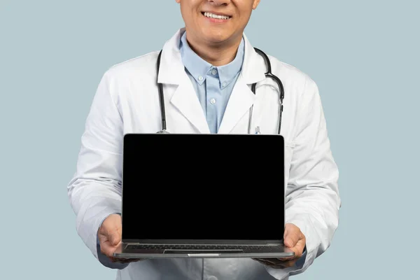 Przycięte Szczęśliwy Średnim Wieku Koreański Lekarz Białym Płaszczu Pokazuje Laptopa — Zdjęcie stockowe