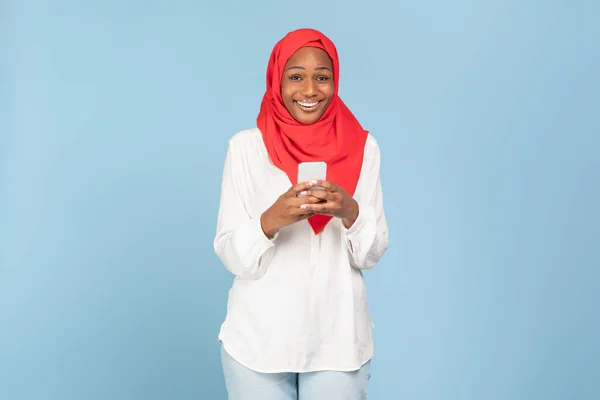 Χαρούμενη Μαύρη Μουσουλμάνα Κυρία Μαντίλα Που Κρατάει Smartphone Και Χαμογελάει — Φωτογραφία Αρχείου