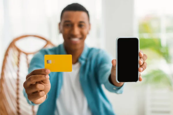 Veselý Mladý Černoch Prodavač Nenucené Ukázce Kreditní Karty Smartphonu Prázdnou — Stock fotografie