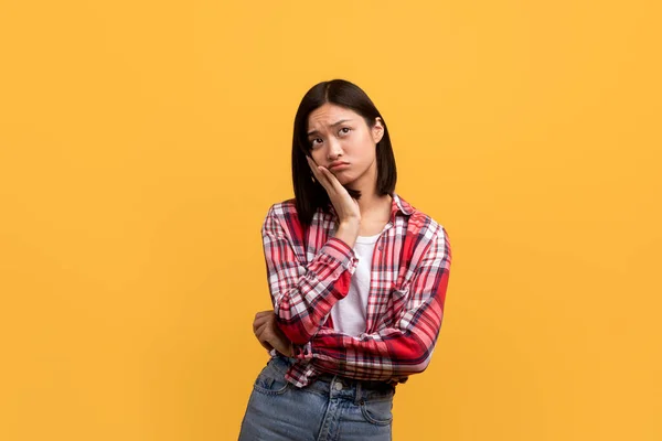 Nachdenkliche Zweifelnde Asiatische Dame Die Den Kopierraum Auf Gelbem Studiohintergrund — Stockfoto