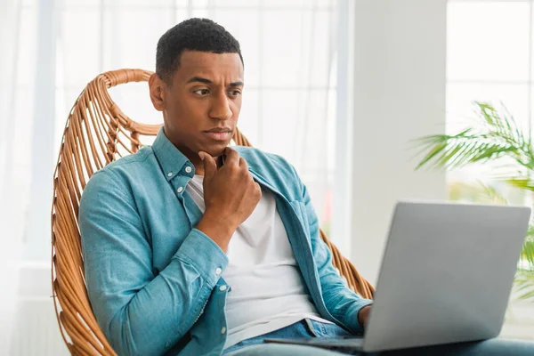 Σοβαρά Σκεπτικός Όμορφος Νεαρός Μαύρος Άνδρας Casual Κοιτάζει Φορητό Υπολογιστή — Φωτογραφία Αρχείου