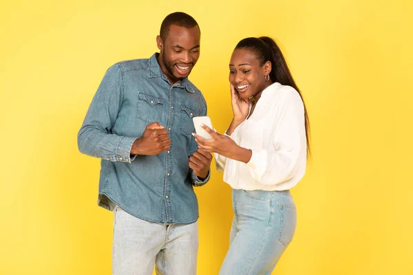 Freudige Schwarze Ehepartner Mit Smartphone Und Zitternden Fäusten Vor Freude — Stockfoto