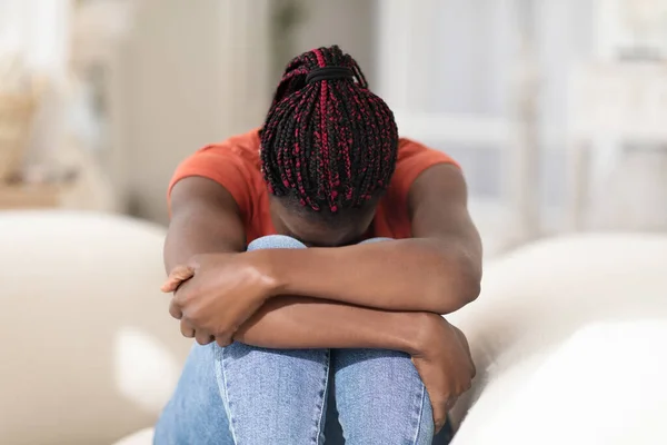 精神崩溃 忧心忡忡的年轻非洲裔美国妇女坐在沙发上哭泣 沮丧的黑人女性埋在膝盖里 感到孤独和悲伤的画像 复制空间 — 图库照片