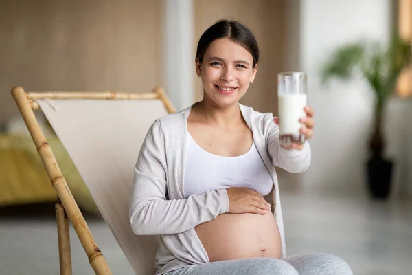 Hamilelik Sağlığı Gülümseyen Bir Kadın Evde Sandalyesinde Otururken Kameraya Sütle — Stok fotoğraf
