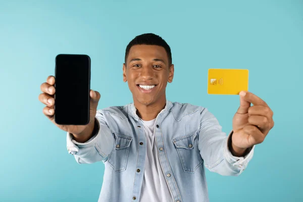 Uśmiechnięty Atrakcyjny Afrykański Facet Dżinsach Pokazuje Smartfona Czystym Ekranem Kartą — Zdjęcie stockowe