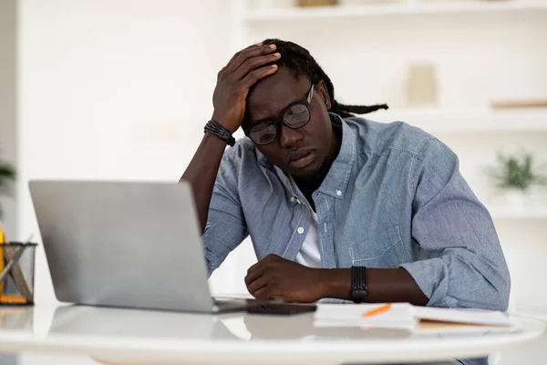 Zmęczony Czarny Mężczyzna Siedzi Przy Biurku Laptopem Dotykającą Głową Myślący — Zdjęcie stockowe