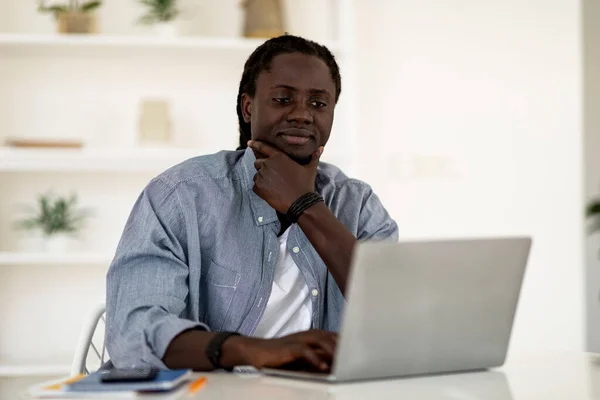 Black Man Browsing Internet Laptop Terwijl Zittend Aan Bureau Thuis — Stockfoto