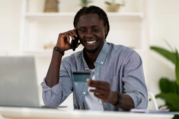 Pagos Línea Hombre Freelancer Negro Sonriente Sosteniendo Tarjeta Crédito Hablando —  Fotos de Stock