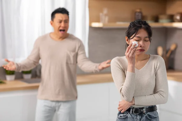 愤怒的亚洲夫妇在家里吵架 愤怒的中年男人对着哭哭啼啼的妻子大喊大叫 夫妻在婚姻 厨房内部 复制空间中经历着危机 — 图库照片