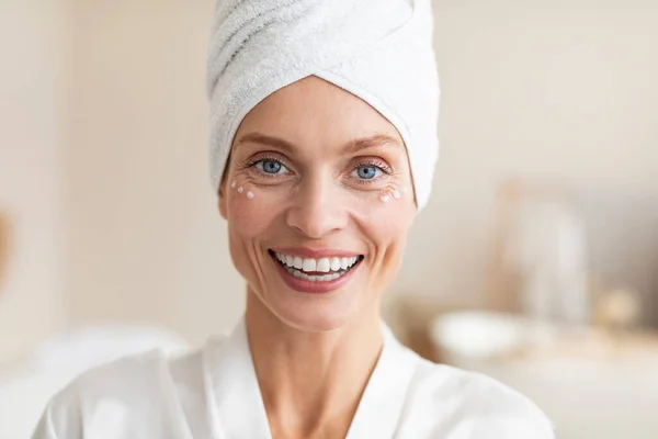 Dojrzała Koncepcja Piękna Czarująca Biała Kobieta Kremem Pod Oczami Uśmiechnięta — Zdjęcie stockowe