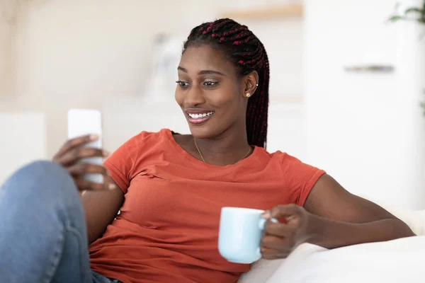 Beautiful Black Young Woman Relaxing Couch Smartphone Coffee Smiling African — Stok Foto