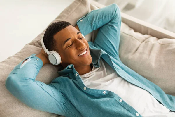 Zufriedener Afrikanisch Amerikanischer Millennial Mann Liegt Auf Dem Sofa Drahtlosen — Stockfoto