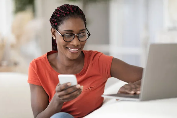 Negócios Remotos Sorrindo Mulher Negra Usando Smartphone Laptop Casa Jovem — Fotografia de Stock