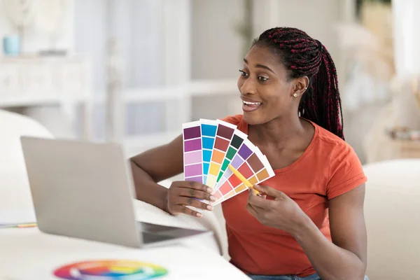 Remote Work. Black Female Interior Designer Using Laptop for Showing Swatches To Client, Smiling Young African American Woman Demonstrating Color Examples During Teleconference, Free Space