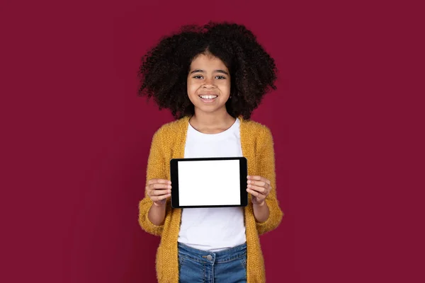 귀여운 초반의 아이는 곱슬곱슬 현대의 디지털 태블릿을 스튜디오 배경에 웃으면서 — 스톡 사진
