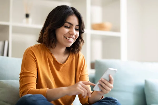 Feliz Jovem Árabe Mensagens Femininas Smartphone Enquanto Relaxa Casa Retrato — Fotografia de Stock