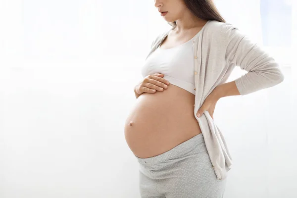 巨根ショットの妊娠中の女性でホームウェアに触れます彼女の大きなおなか 認識できない女性期待待っていますのために赤ちゃん 白いスタジオの背景 パノラマとともにコピースペースのために広告 — ストック写真