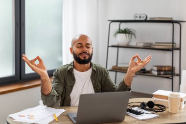 Zen konsepti. Sakin, olgun bir adam, gözleri kapalı, meditasyon yapan, serbest çalışan, siyah erkek, Mudra hareketleriyle el ele tutuşan, ev içi, serbest alan.